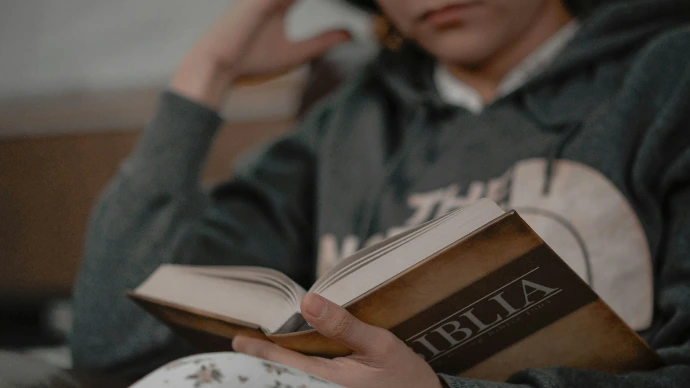 a person sitting on a couch reading a book